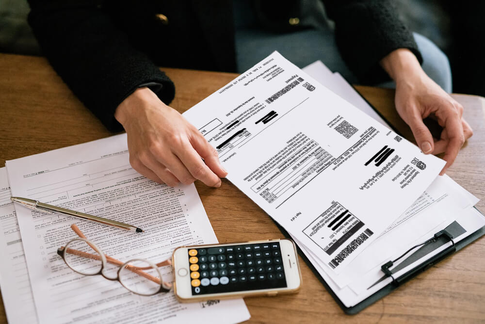 person with irs notice amount tax due on desk with calculator on iphone