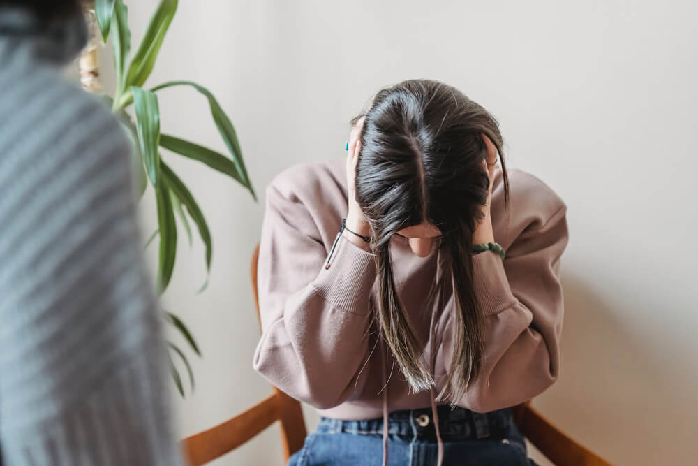woman desperate in chair with head down woman desperate in chair with head down